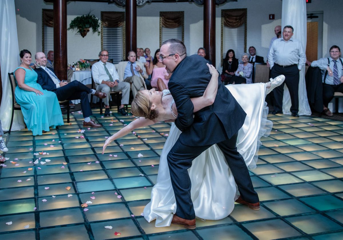 Groom dips bride on the lighted dance floor